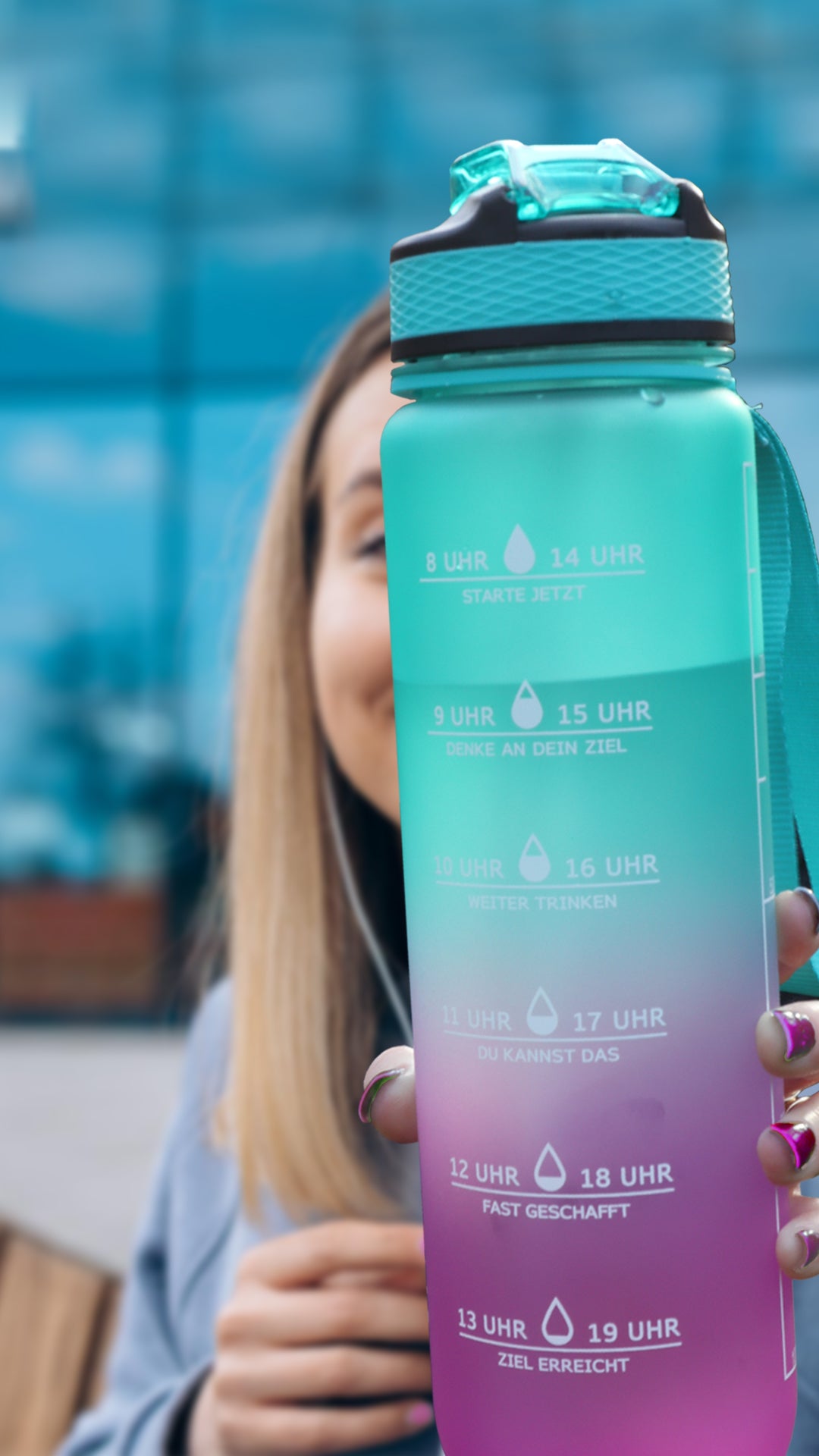 Frau zeigt ihre motivational water bottle um immer ans trinken erinnert zu werden.