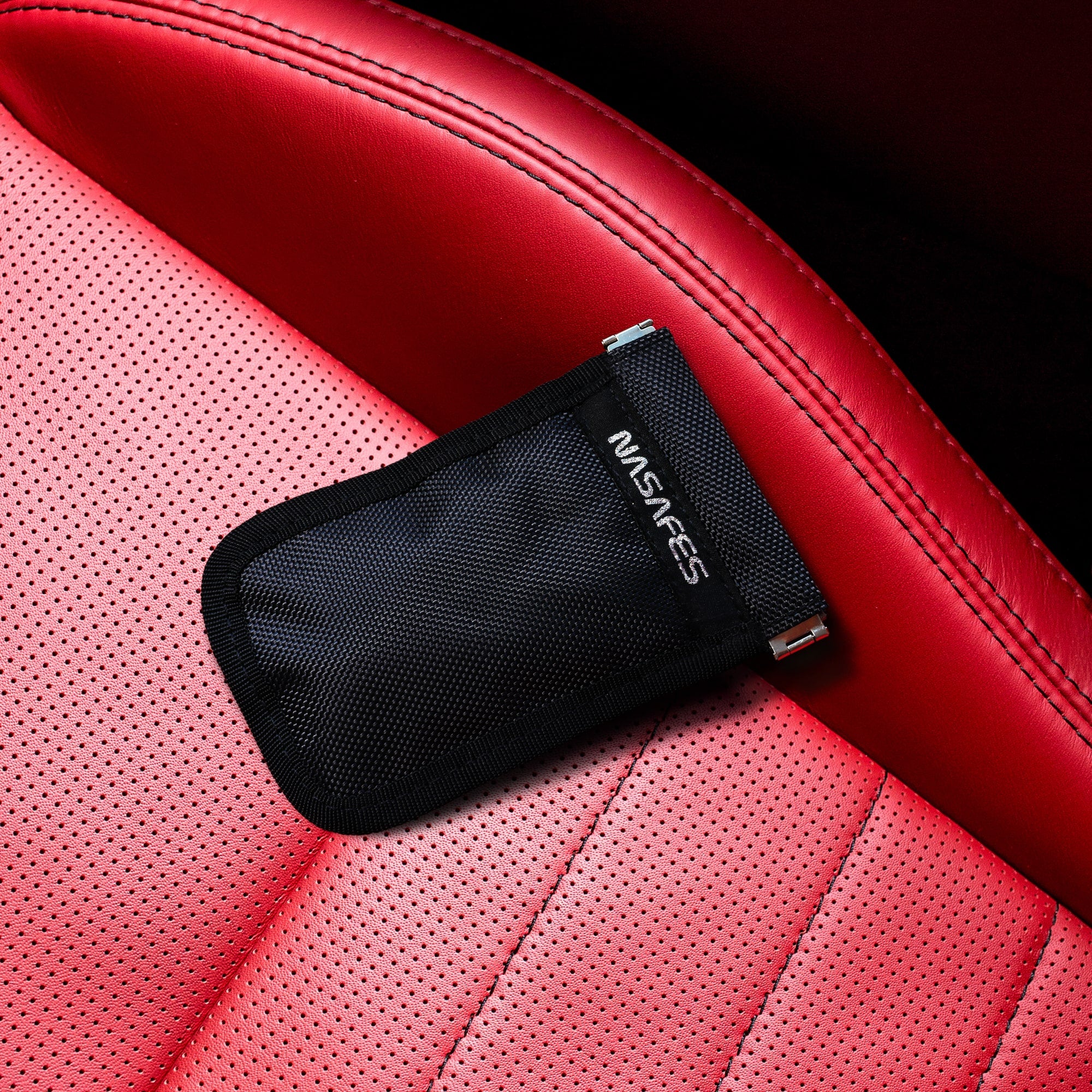 Nasafes Abschirmtasche auf einem roten Autoledersitz